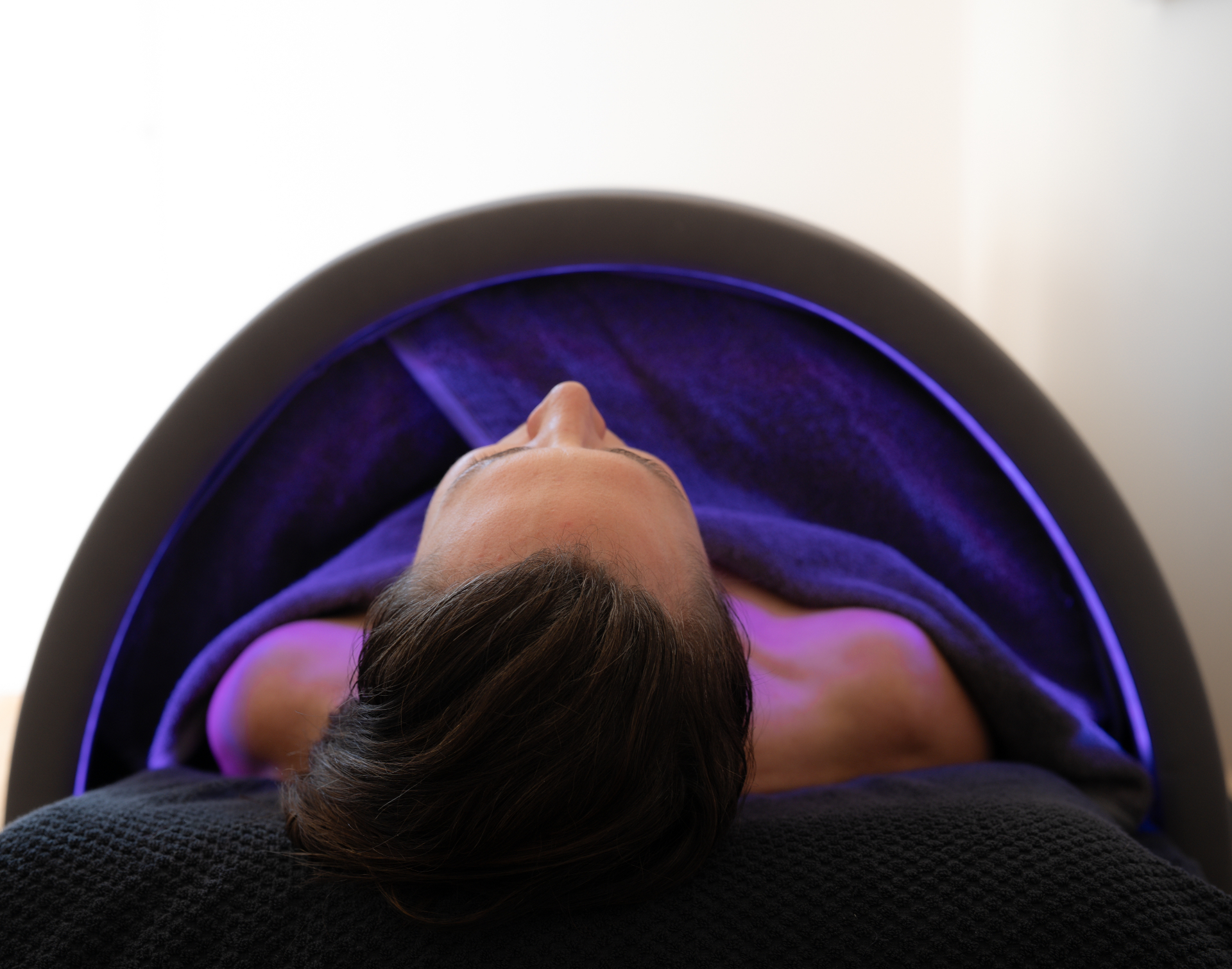 Client relaxing under LED light therapy